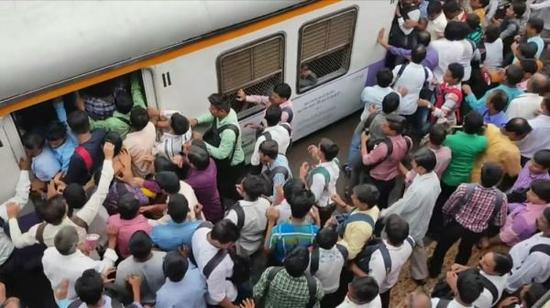 资料图片：印度孟买“通勤族”争先恐后挤上火车（台湾联合新闻网）