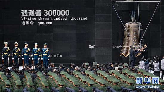 2017年12月13日,南京大屠杀死难者国家公祭仪式在南京举行。图为南京各界代表撞响和平大钟。 新华社 图