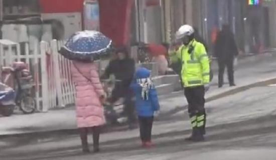山东邹城交警雪中护幼童，两人互相敬礼道别。@公安部交通安全微发布 图