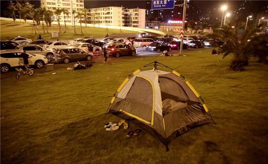 ▲在海口丘海大道上，有的旅客在路边草地上搭起了帐篷，在帐篷中休息等待。图据东方IC