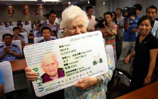 ▲一名获得中国永久居留证的美国人展示自己的“绿卡”。