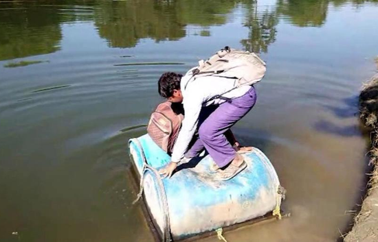 因一大桥施工缓慢 印度孩子用塑料桶渡河上学