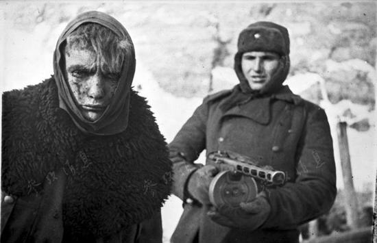 资料图:1943年,斯大林格勒战役后,一名手持PPSh-41冲锋枪的苏军士兵在押解一名德军俘虏。