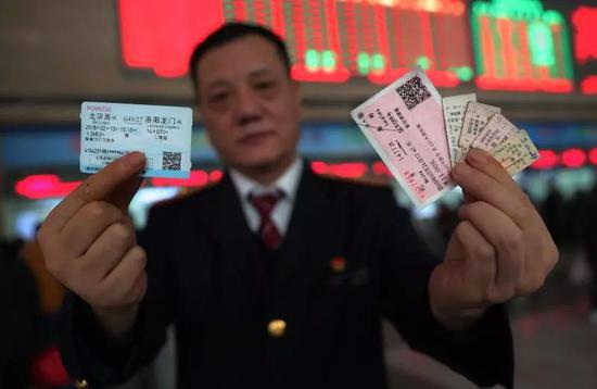2018年2月7日，康顺兴右手拿着现在使用的高铁票，左手拿着老火车票。新京报记者尹亚飞 摄