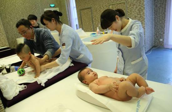 资料图片:1月30日,母婴家庭保健师在上海一家月子会所内护理婴儿。新华社记者 裴鑫 摄