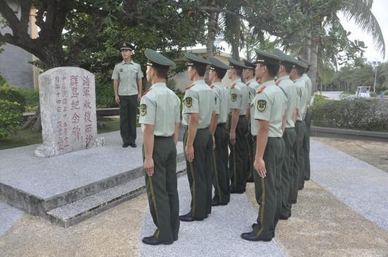 武警三沙中队官兵在纪念碑前进行爱国主义教育。