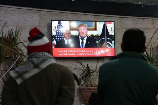 当地时间2017年12月6日，加沙加沙城，巴勒斯坦人关注特朗普承认耶路撒冷为以色列首都的新闻报道。 视觉中国 图