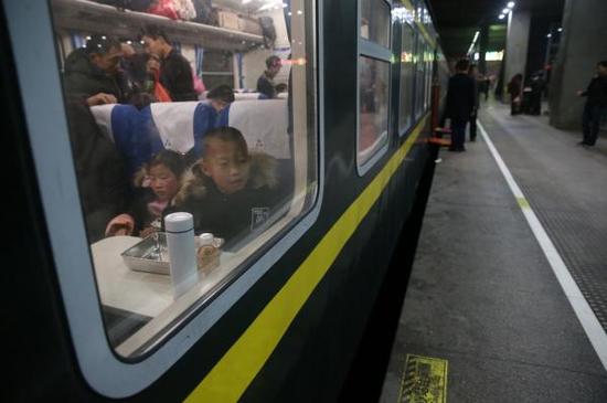 2月1日凌晨,旅客乘坐由上海南发往重庆北的K4085次列车。此趟列车是由上海始发的第一列春运列车。 新华社 图