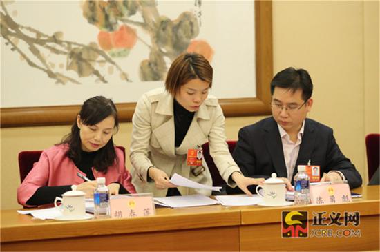 全国人大代表胡春莲(左)全国人大代表陈勇彪(右)在全国人大代表朱登云提出的联名附议代表签名附页中签名附议。记者张哲 摄