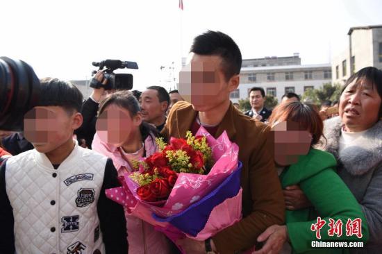材料图:须眉任渊(抱花者)3岁遭拐卖,20年后与亲生父母相认。赵伟 摄