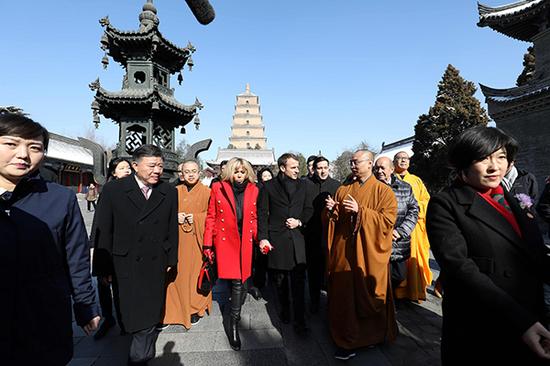 马克龙在参观大雁塔时，聆听寺院僧人做讲解。