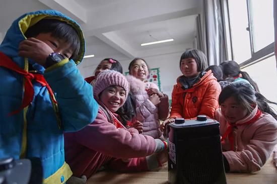 社会爱心人士捐赠的暖风器,孩子下课后围在一起取暖。