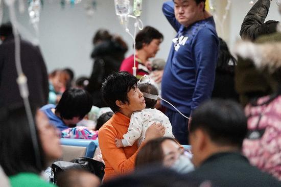 ▲ 一名家长在北京儿童医院陪同患儿输液。 图/新华社