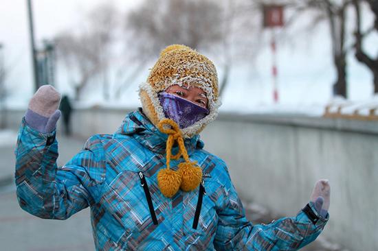 哈尔滨街头，出行的市民全副武装，露出的眉毛、睫毛上带着哈气凝结的白霜，宛如化了一个“冰花妆”。