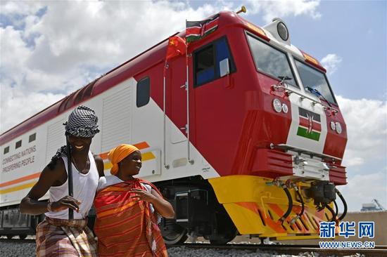 2017年1月11日，在肯尼亚蒙巴萨，当地民众在中国承制的蒙内铁路首批内燃机车旁载歌载舞。 新华社记者 孙瑞博 摄