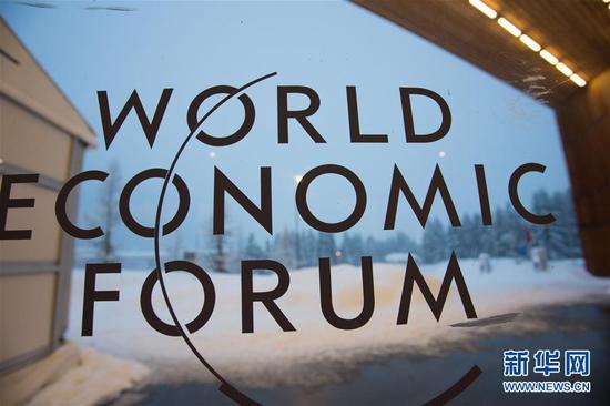 这是2018年1月22日在瑞士达沃斯会议中心拍摄的世界经济论坛的标志。世界经济论坛将“在分化的世界中打造共同命运”定为2018年年会主题。新华社记者 徐金泉 摄