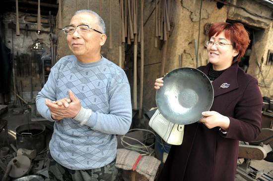 买锅客拿着成品铁锅与牛祺圣合影