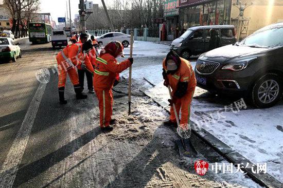 3月1日10时许,辽宁营口市区道路出现结冰,环卫工人进行除冰工作。(王浩宇 摄)