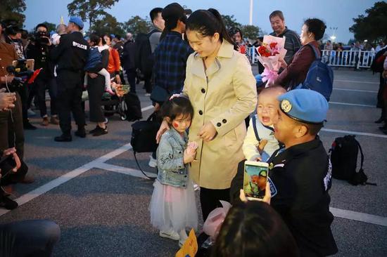 (2018年3月1日,南宁国际机场,秦宗润第一次亲眼见到9个月的儿子,而5岁的女儿也远远躲着他。陈志荣/摄)