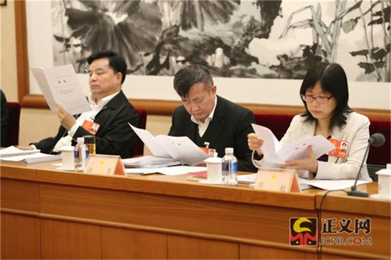 全国人大代表王少峰(左)全国人大代表谢勇(中)全国人大代表周敏翻阅当日简报。记者张哲 摄