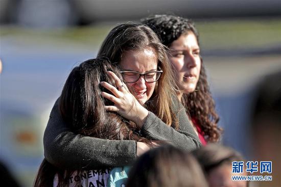 2月14日，在美国佛罗里达州帕克兰市发生枪击的高中，安全撤离的学生相拥而泣。美国佛罗里达州布劳沃德县警方14日说，当地一高中发生的枪击案已造成17人死亡。 新华社/美联