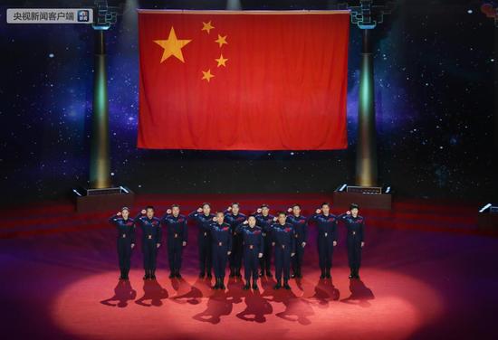 12名航天员代表在时代楷模发布仪式现场面向国旗庄严宣誓,“甘愿为载人航天事业奋斗终生”。前排左起:费俊龙、杨利伟、聂海胜,后排左起:王亚平、张晓光、刘旺、景海鹏、翟志刚、刘伯明、邓清明、陈冬、刘洋。
