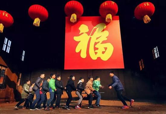 拍全村福前,孩子们在福字下玩“老鹰捉小鸡”。受访者供图