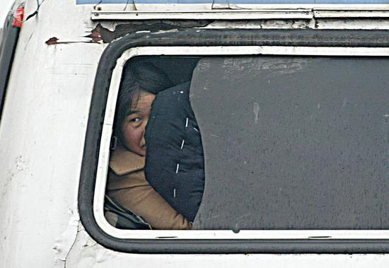 2004年1月，杭宁高速公路长兴段，一辆开往安徽的卧铺客车正在接受检查，车尾的乘客扒开行李，透过破窗艰难地往外张望。