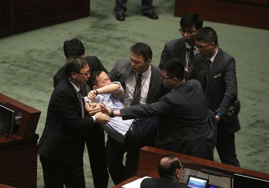 反对派议员冲击主席台,被保安抬走。图片来源于港媒