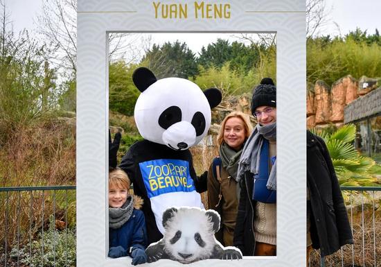 1月13日，在法国圣艾尼昂市博瓦勒野生动物园，游客与装扮成熊猫的工作人员合影。（新华社记者陈益宸摄）