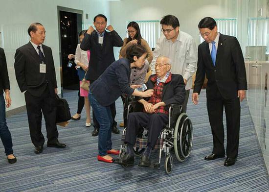 2014年10月，香港浸会大学饶宗颐学术研讨会，饶宗颐先生与本文作者（推轮椅者）合影。作者供图