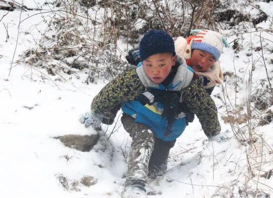 新华社:9岁男孩背弟弟雪中走近一小时山路 只为去新家