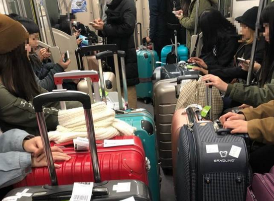 台湾旅客日本列车内行李挡道，被广播提醒后改装睡。（图片来源：台湾《中时电子报》）