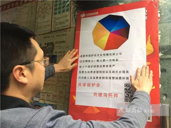 ▲陈杰在张贴公司海报。图片来自成都商报