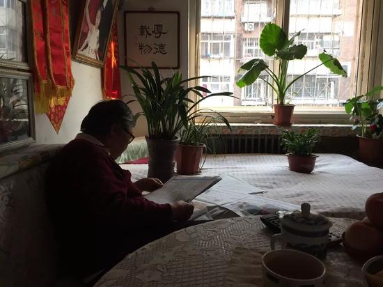 老赵的妻子孙秀兰在家看报。新京报记者陶若谷 摄