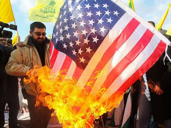 1月28日，黎巴嫩南部一座村庄，真主党支持者在反对美国总统特朗普承认耶路撒冷为以色列首都的集会上焚烧美国国旗。（新华/法新）