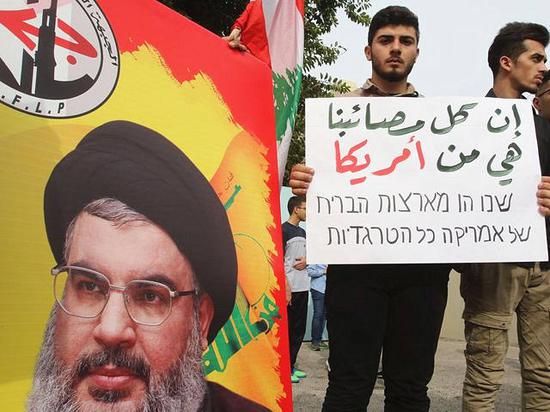 2017年12月21日，黎巴嫩南部，抗议民众举着真主党总书记纳斯鲁拉宣传像，反对美国承认耶路撒冷为以色列首都。（新华/法新）