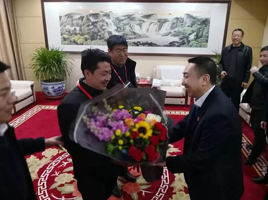 临猗县委书记于鹏飞(右三)将一捧鲜花送给李朋璇。