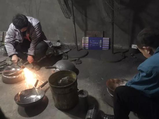 3月1日，聂震（右）在厂房里打磨锅具。