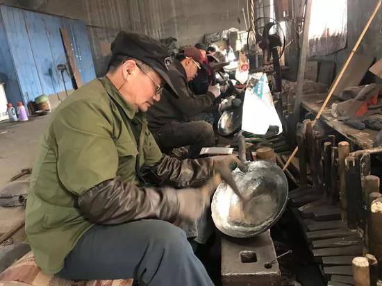2月28日下午，章丘西营村的一个厂房里，铁匠们正在打制铁锅。新京报记者王佳慧 摄