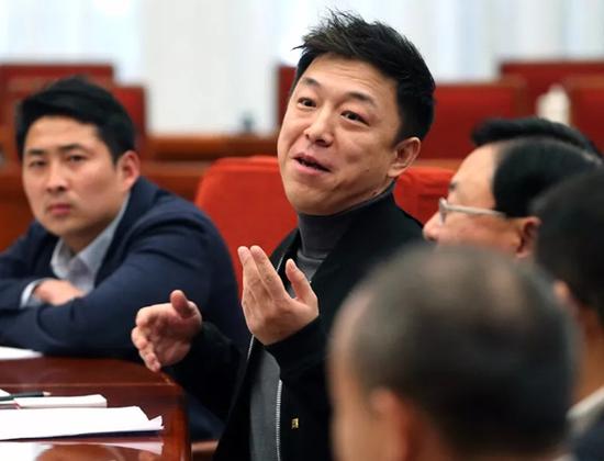 9人中演员黄渤发言,李朋璇(左)坐在他旁边。 中国政府网 图