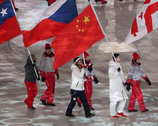 ▲2月25日,中国运动员武大靖(右二)手举中国国旗在闭幕式上入场。 图/新华社