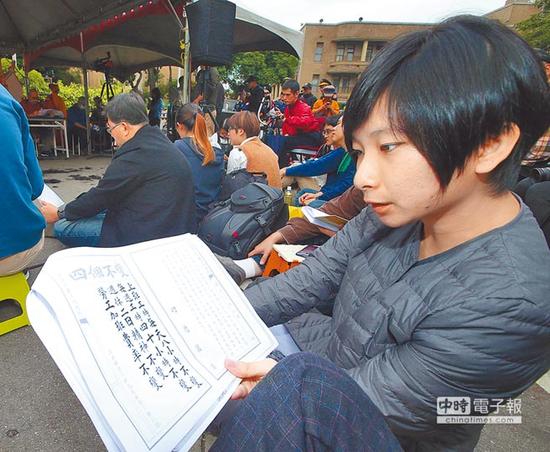 反对“劳基法”再修,劳团与青年团体在Facebook成立“过劳功德会”粉丝页,3日在台当局“行政院”大门口前唱诵“劳基法经”表达不满。(图片来源:台湾《中时电子报》)