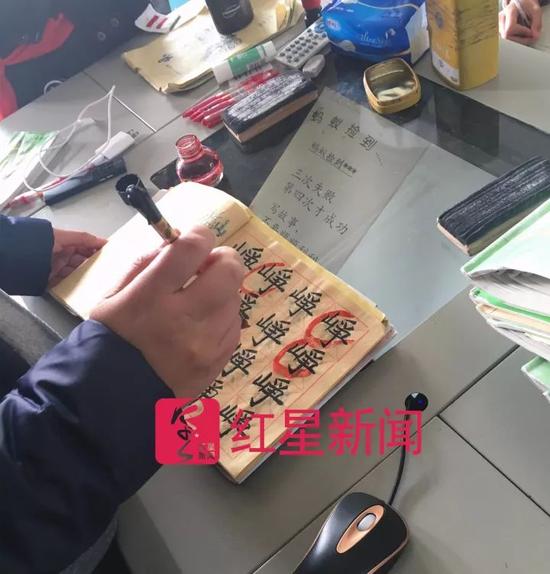 ▲王悦微在课堂上批改学生的作文和书法作业 图片来源:红星新闻