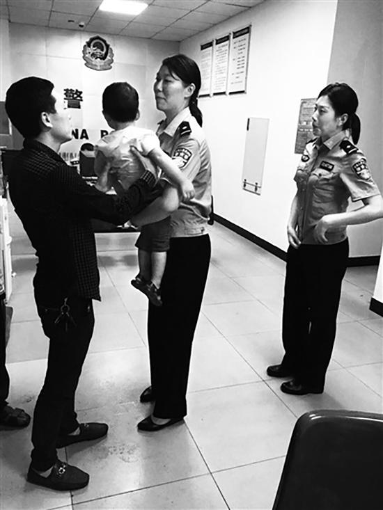 民警将被拐骗儿童还给家长。