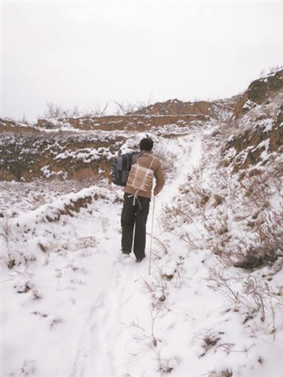 杨会平老师背着试卷爬山路。中国教育报 图