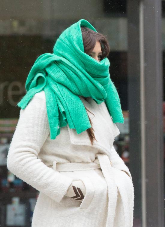 12月30日，在波士顿，一名女子戴着围巾、穿着厚厚的冬装在的街上行走。 当地最低气温已达零下14摄氏度。 