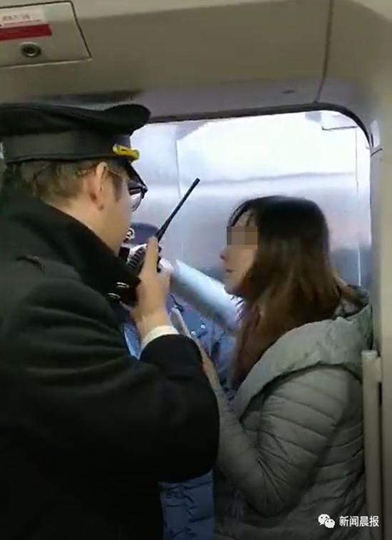 媒体曝出的视频显示，这名女子攥着车门把手，任凭多名铁路工作人员在旁边警告、劝说就是不放手。  “新闻晨报”微信公众号 图
