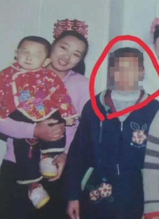 2006年春天，万秀玲（左）抱着小儿子与女儿汤兰兰（右）合影。当日是汤兰兰的叔叔汤继彬的婚礼，两年后，汤兰兰向公安举报汤继彬对其强奸。受访者供图