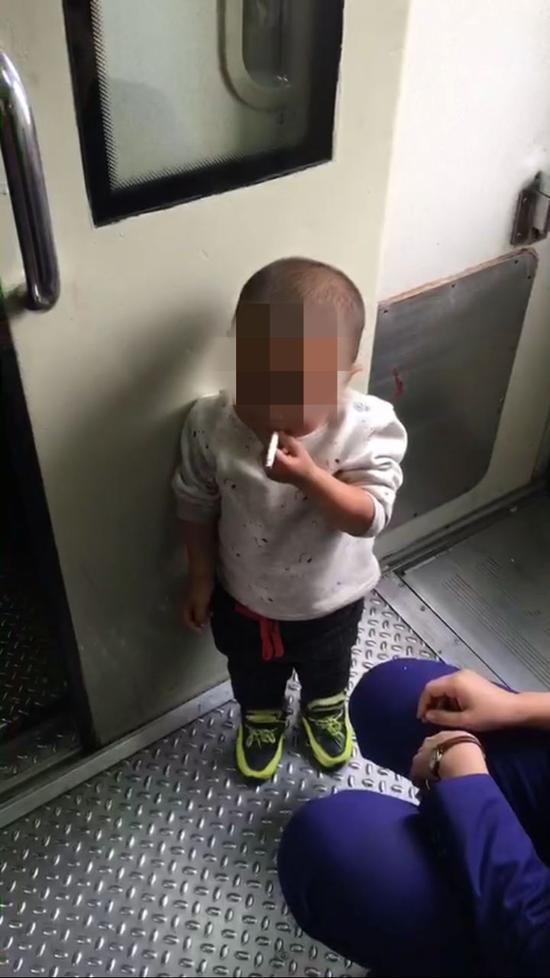 扬子晚报:4岁男孩火车上淡定抽烟 乘警夺下烟批评其父(图)